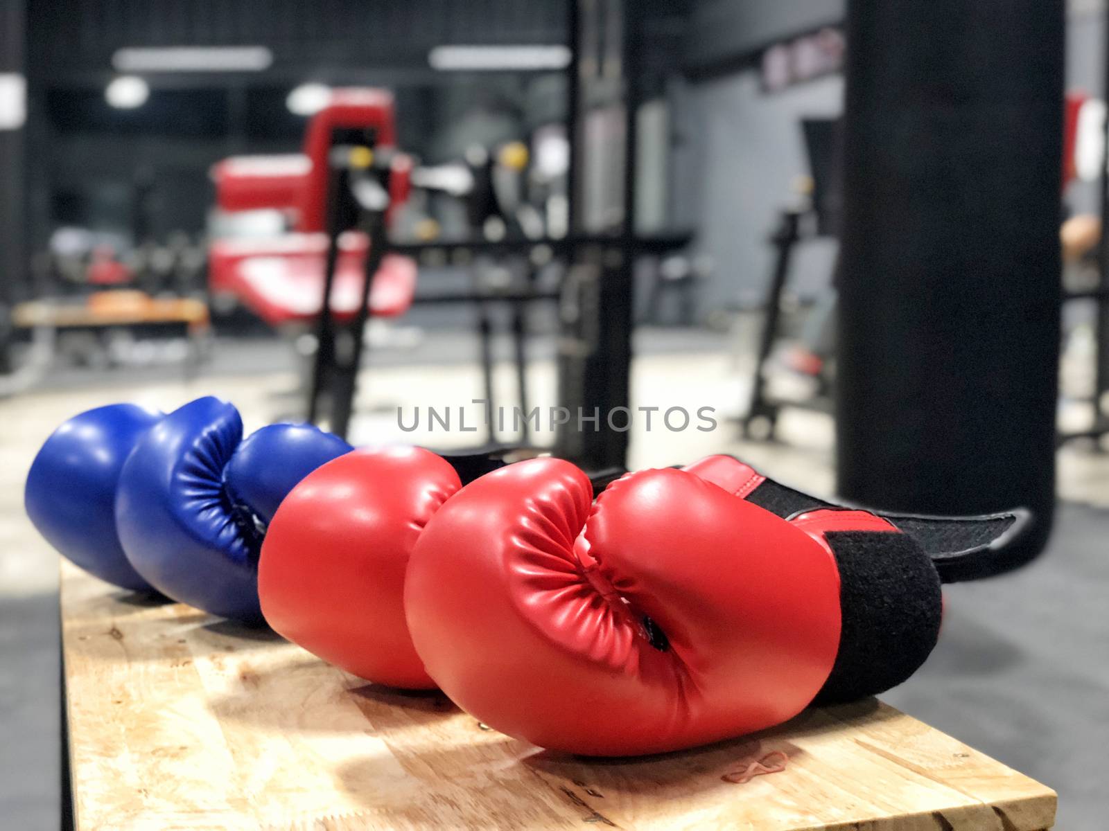 Boxing gloves on wood table in fitness gym by Surasak