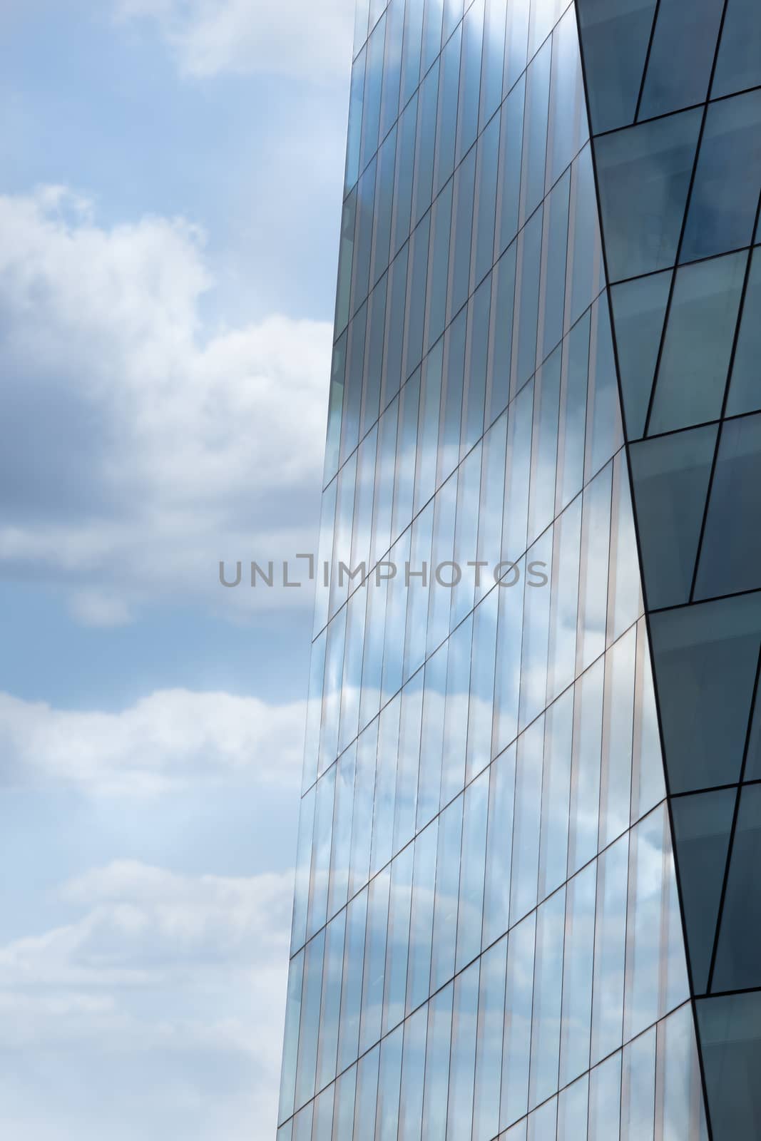 Blue sky reflected in the exterior glass facade of a modern corporate building by magicbones