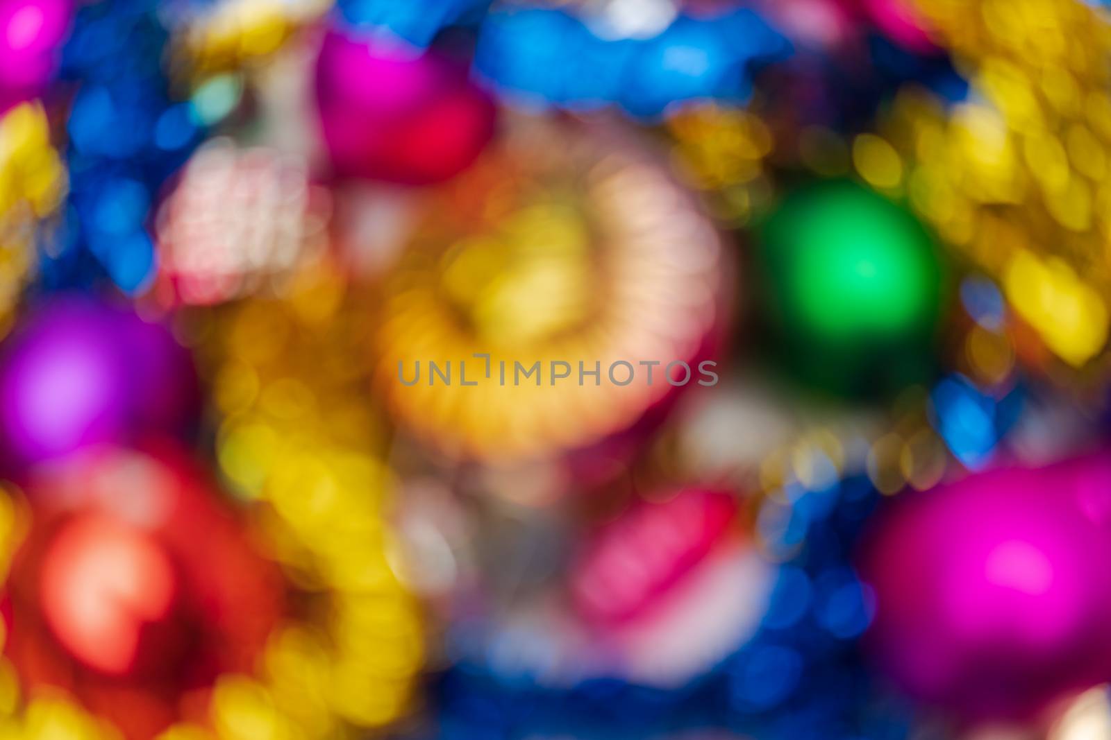 Defocused bright Christmas balls holiday decorations, abstract blurry bokeh background effect. Out of focus glowing lights celebration texture for use at graphic design.