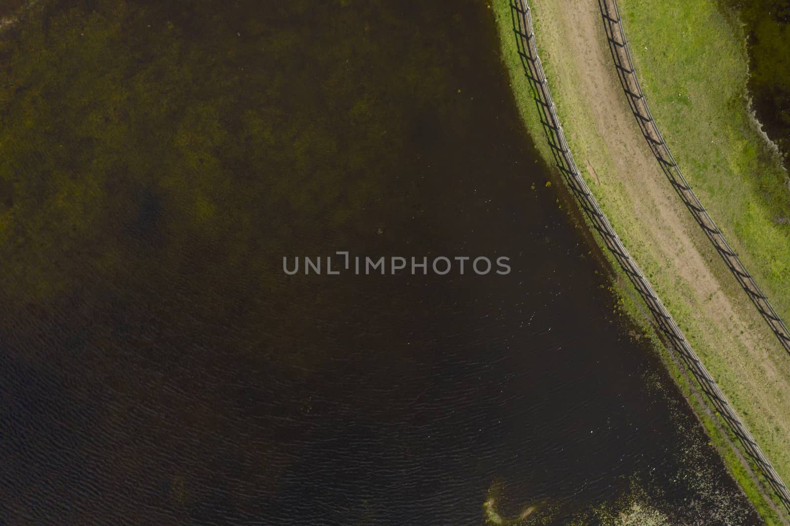 Aerial photograph of a horse trotting track near a lake by WittkePhotos