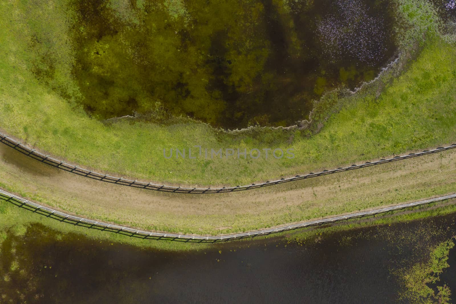 Aerial photograph of a horse trotting track near a lake by WittkePhotos