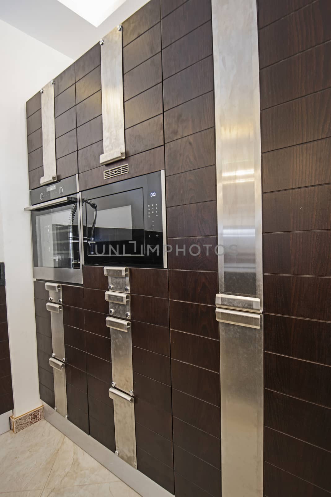 Interior design decor showing modern kitchen with cupboards and built in cooker in luxury apartment showroom