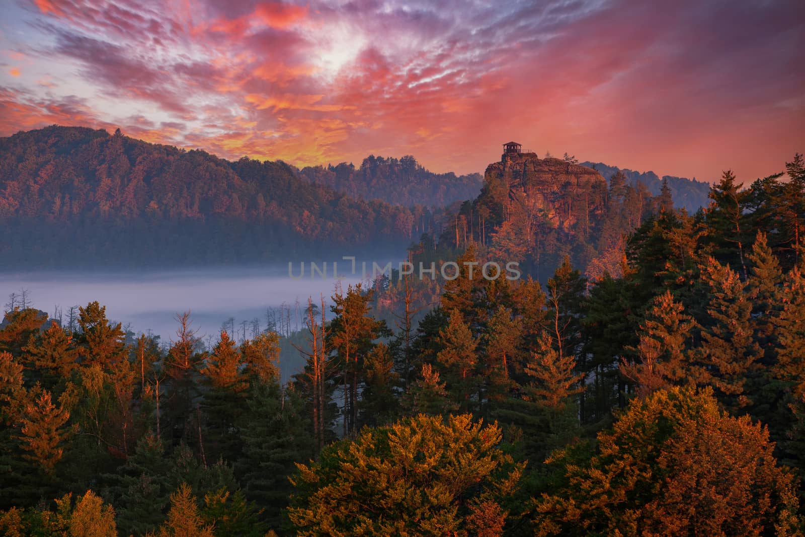 sunset over foggy valley and viewpoint Mariina skala in the national park Bohemian Switzerland, Czech Republic