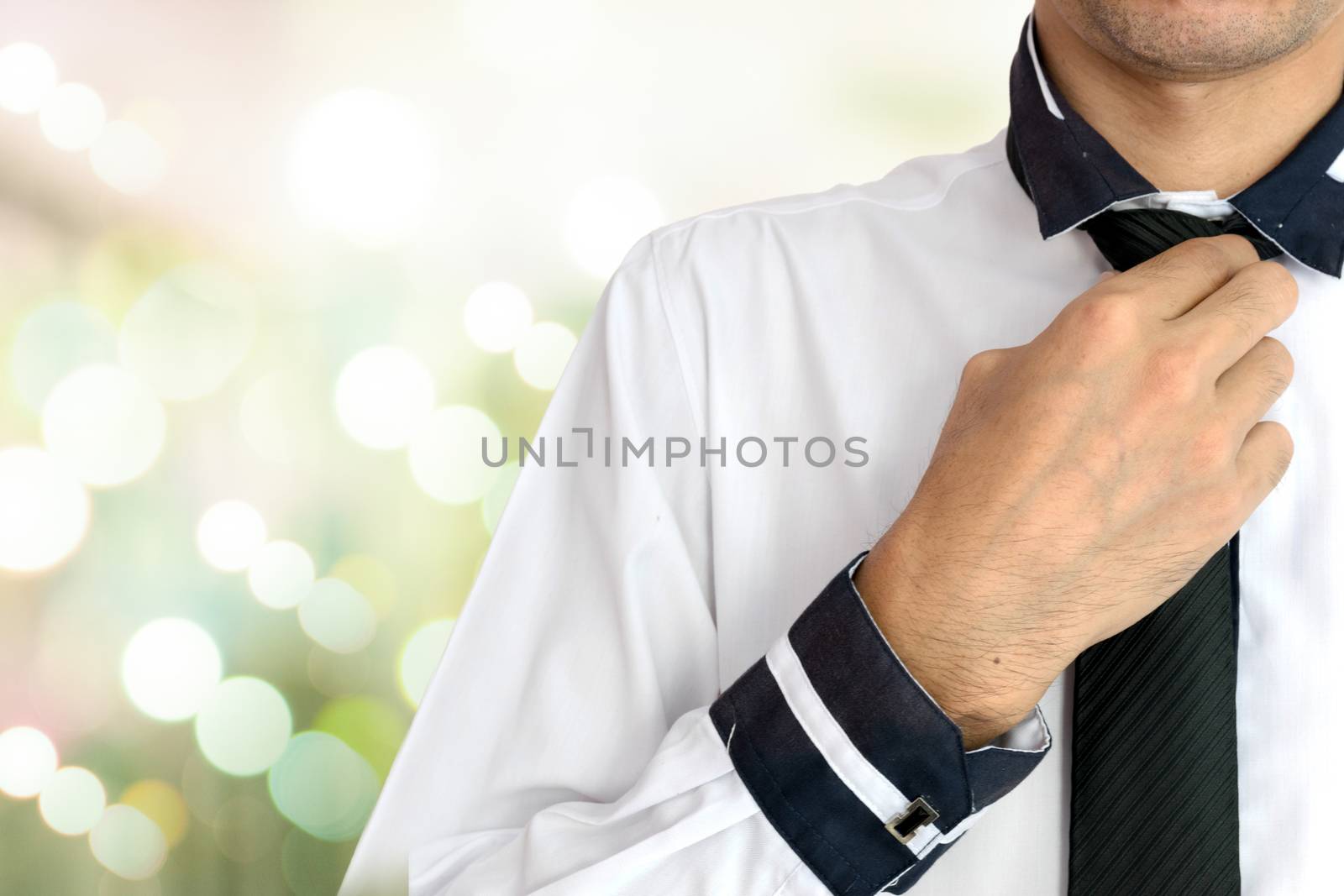 Young businessman Wearing a white shirt and black tie on lighting background.