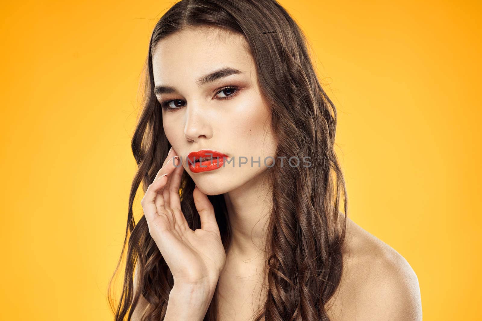 Woman with bare shoulders red cropped lips charm yellow background. High quality photo