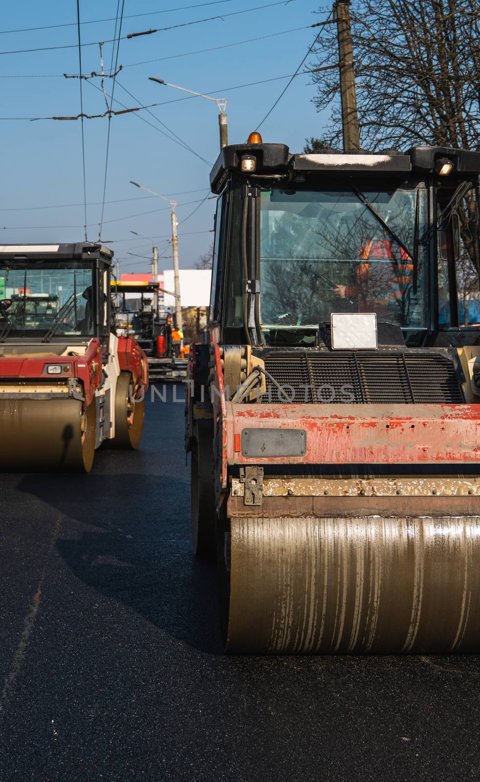 Asphalt road roller with heavy vibration roller compactor press new hot asphalt on the roadway on a road construction site. Heavy Vibration roller at asphalt pavement working. Repairing