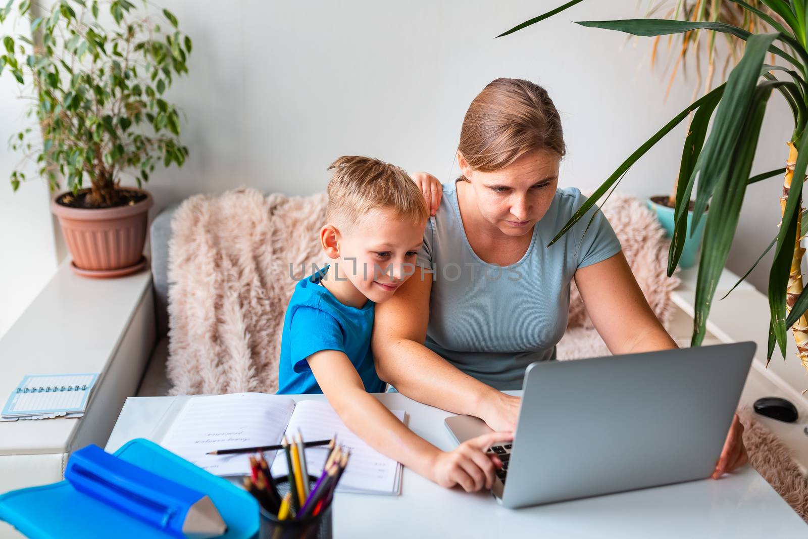 Mother with kid trying to work from home during quarantine. Stay at home, work from home concept during coronavirus pandemic