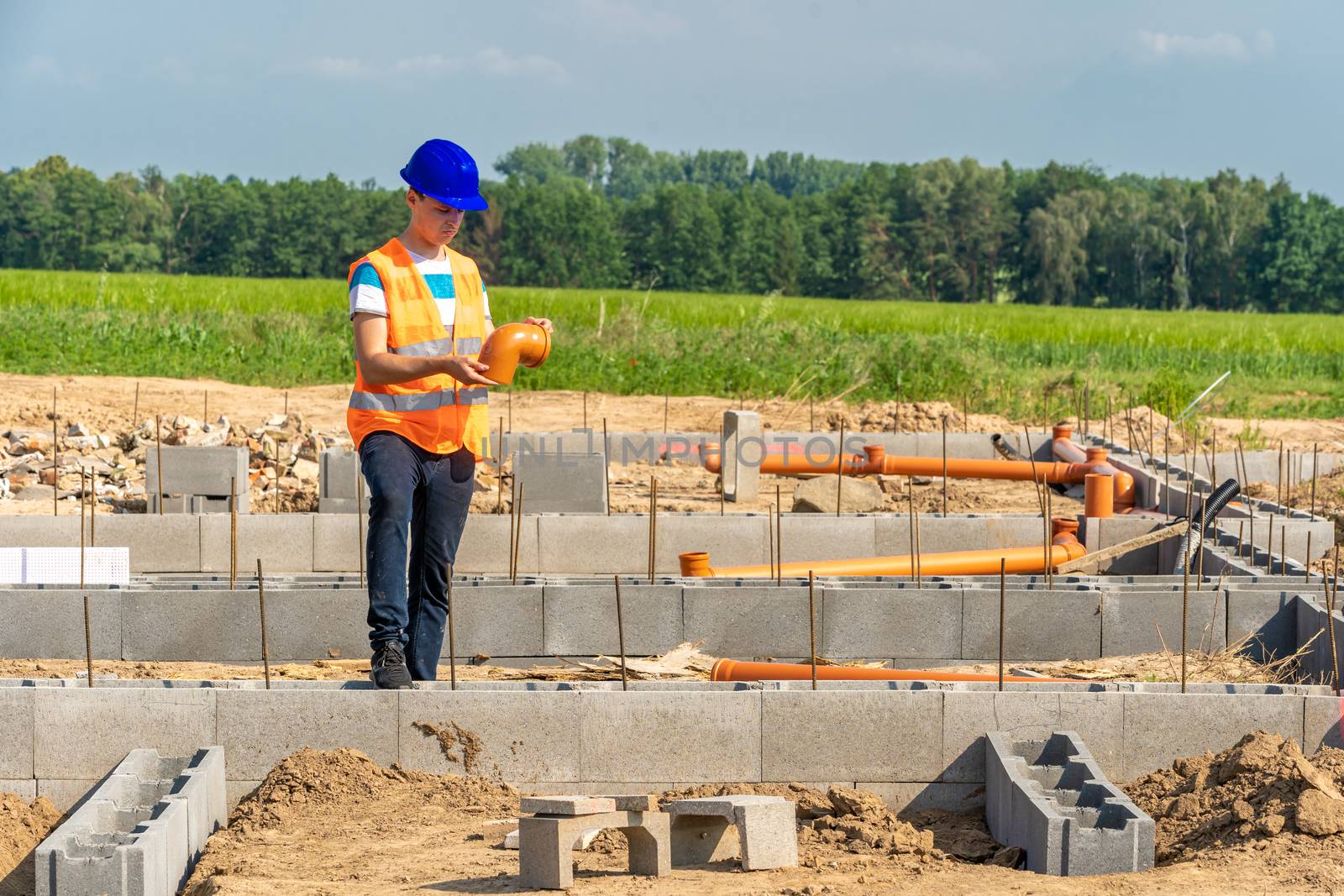 laying plastic pipes to the foundation of the building by Edophoto