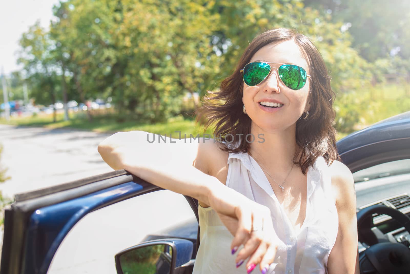 Beautiful girl is standing near her car. open the door of vehicle