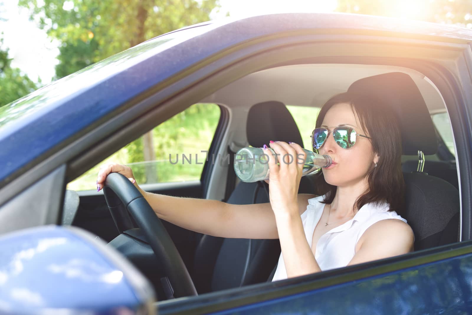 need to drink water every day, anywhere. beautiful brunette behind the wheel. drink driving.