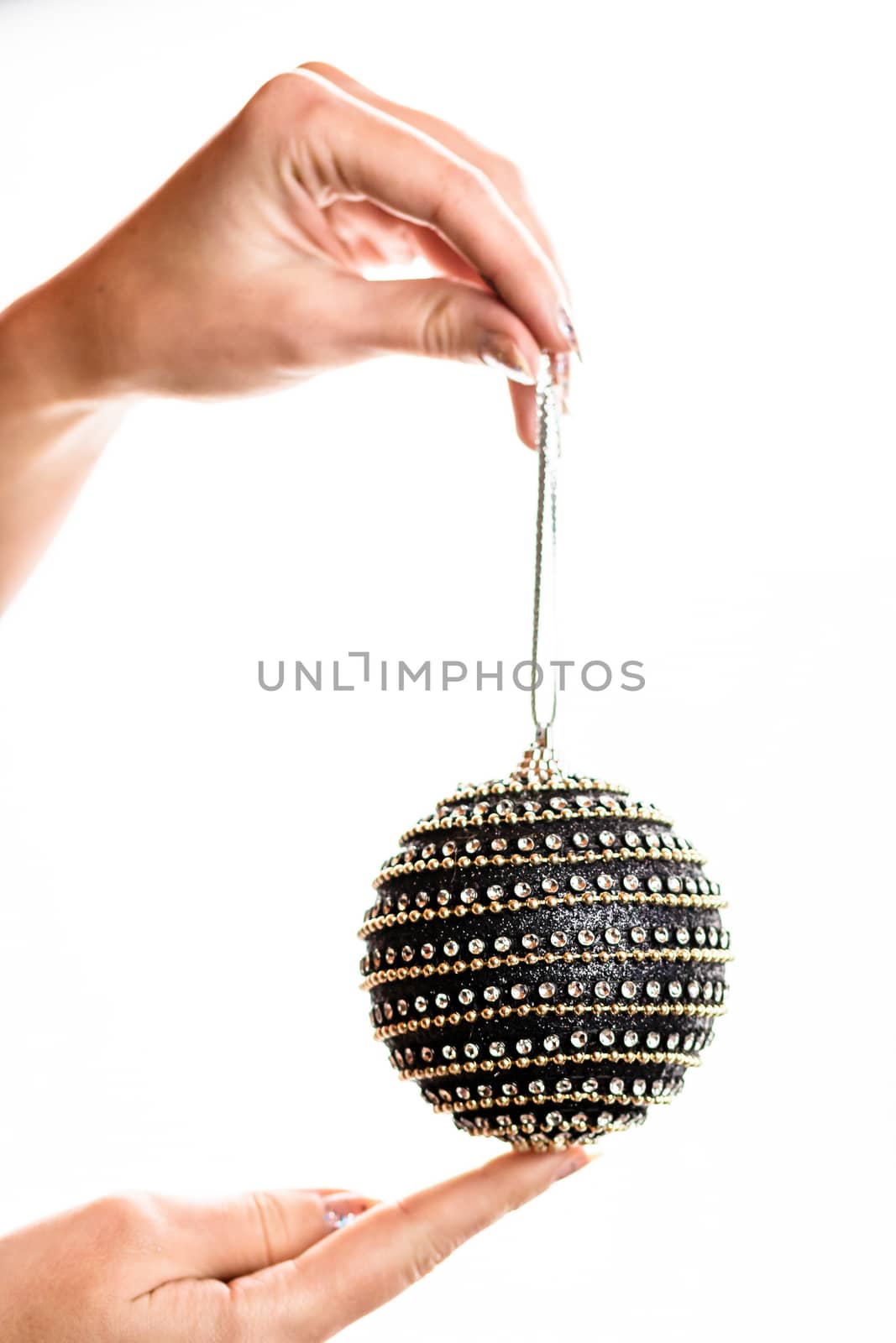 Hand holding showing giving or receiving Christmas bauble decoration isolated on white background