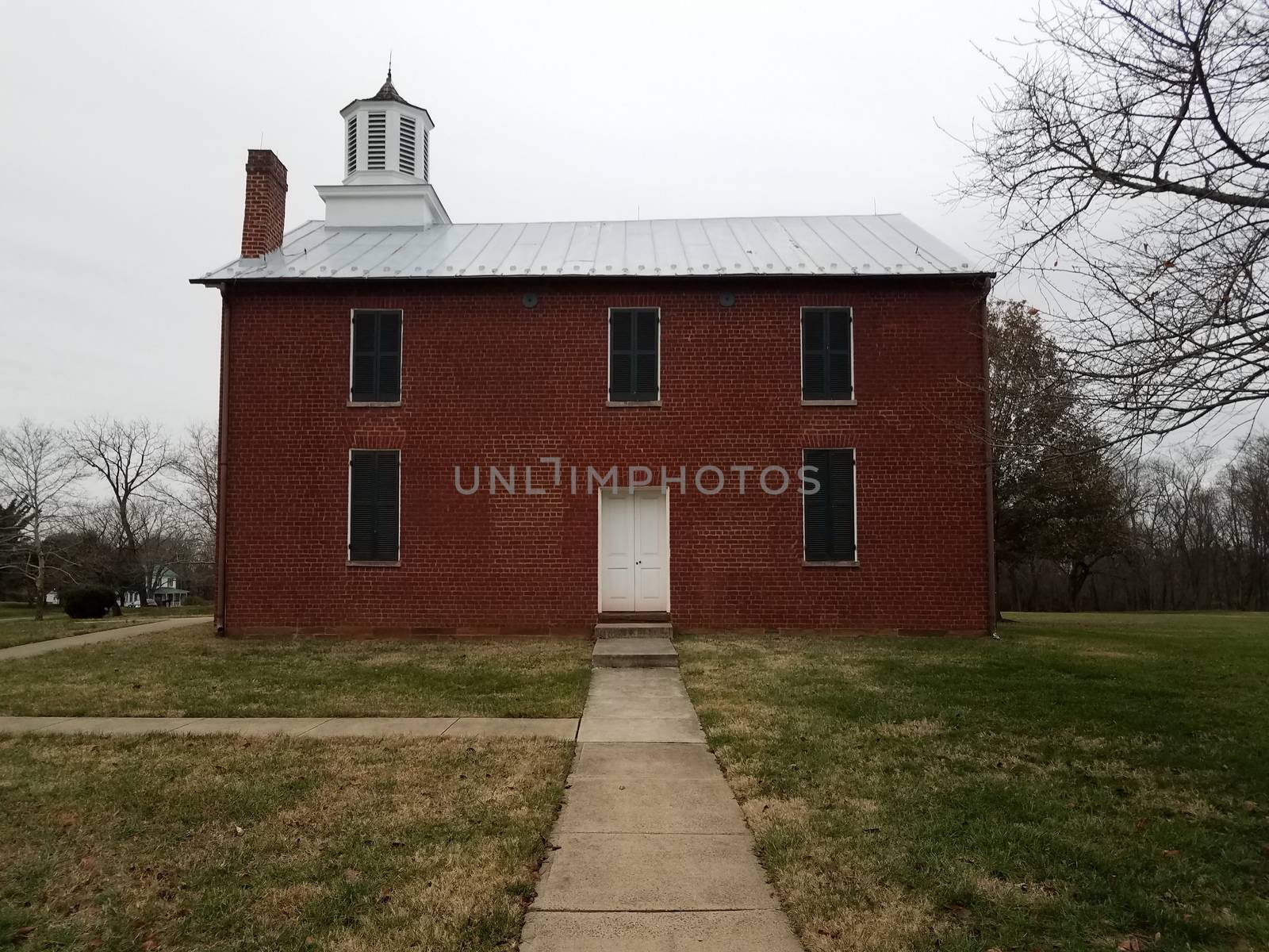 red brick or masonry building with sidewalk and grass