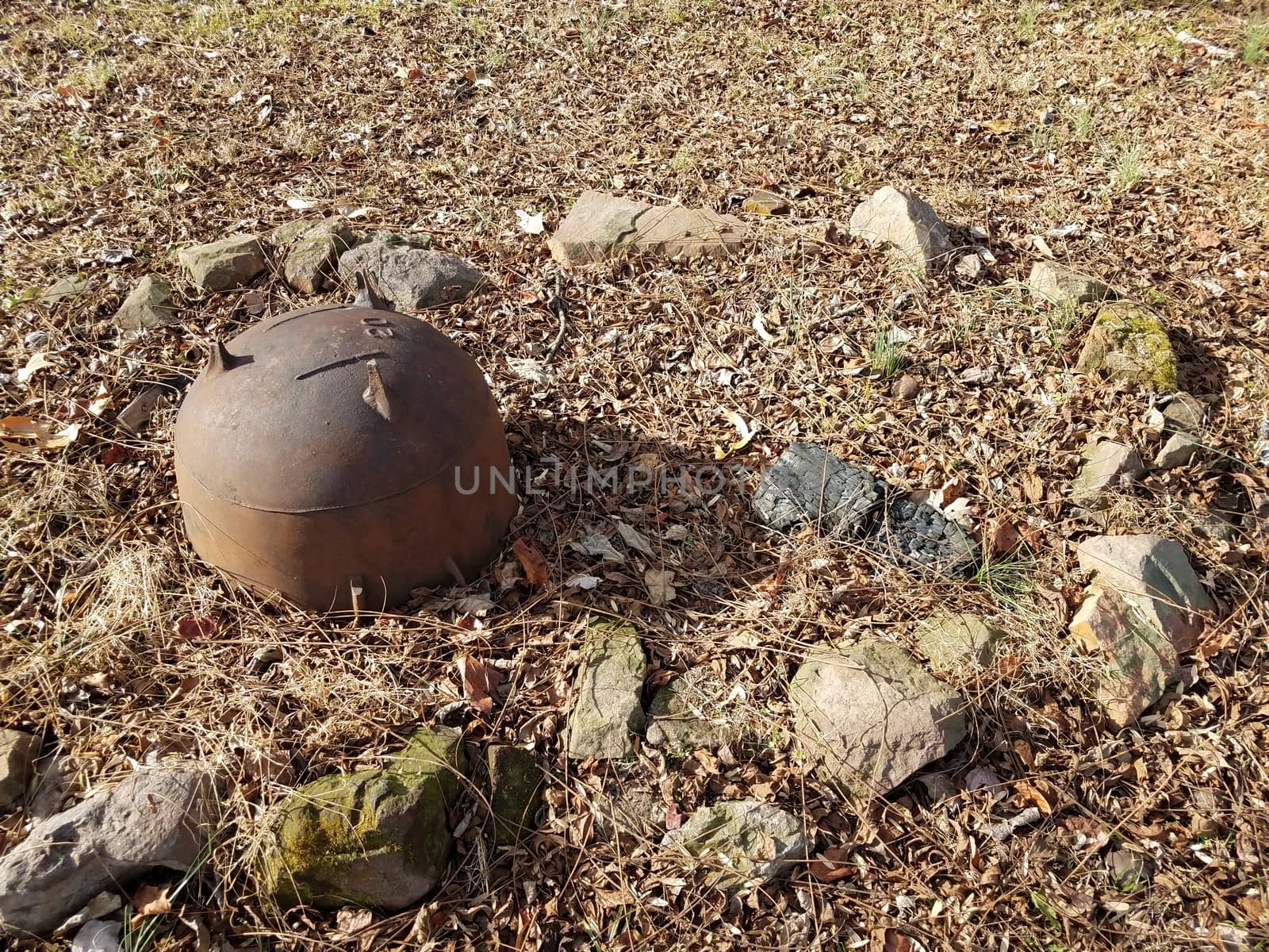 rocks and rusty iron metal cauldron in a circle