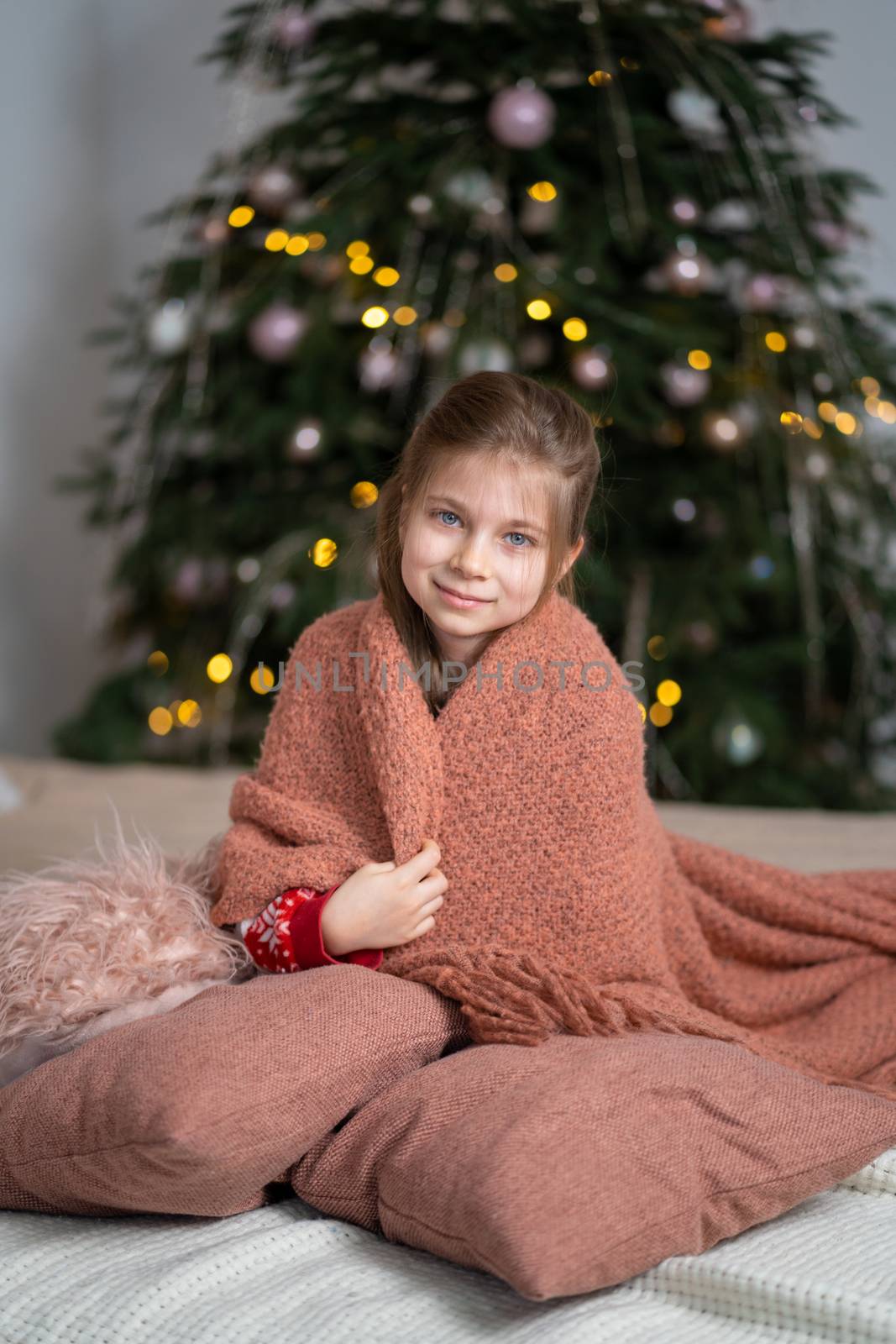 A little girl keeps warm under a cozy knitted blanket by Try_my_best