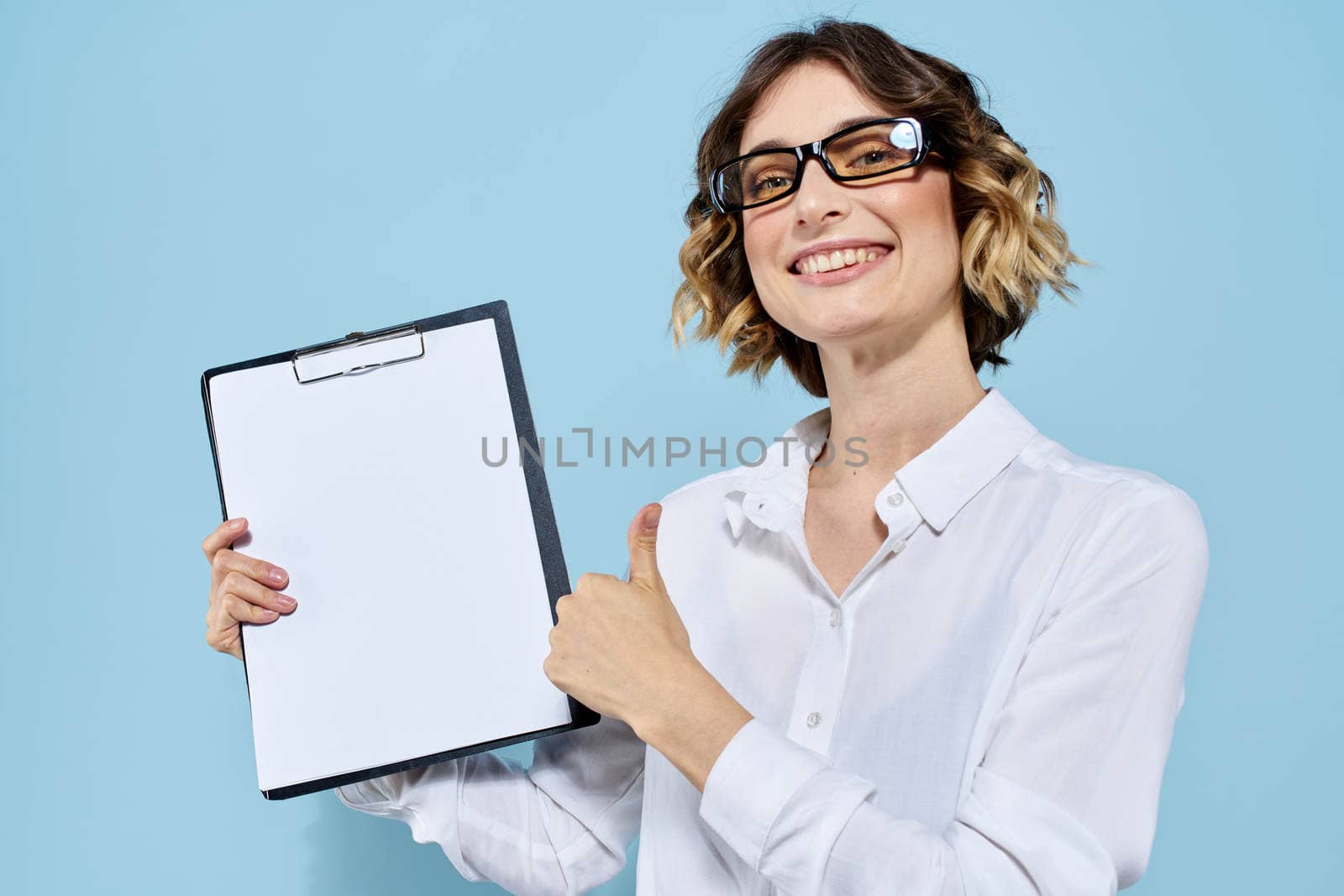 Business woman with documents in a folder on a blue background and in a light shirt glasses on her face. High quality photo