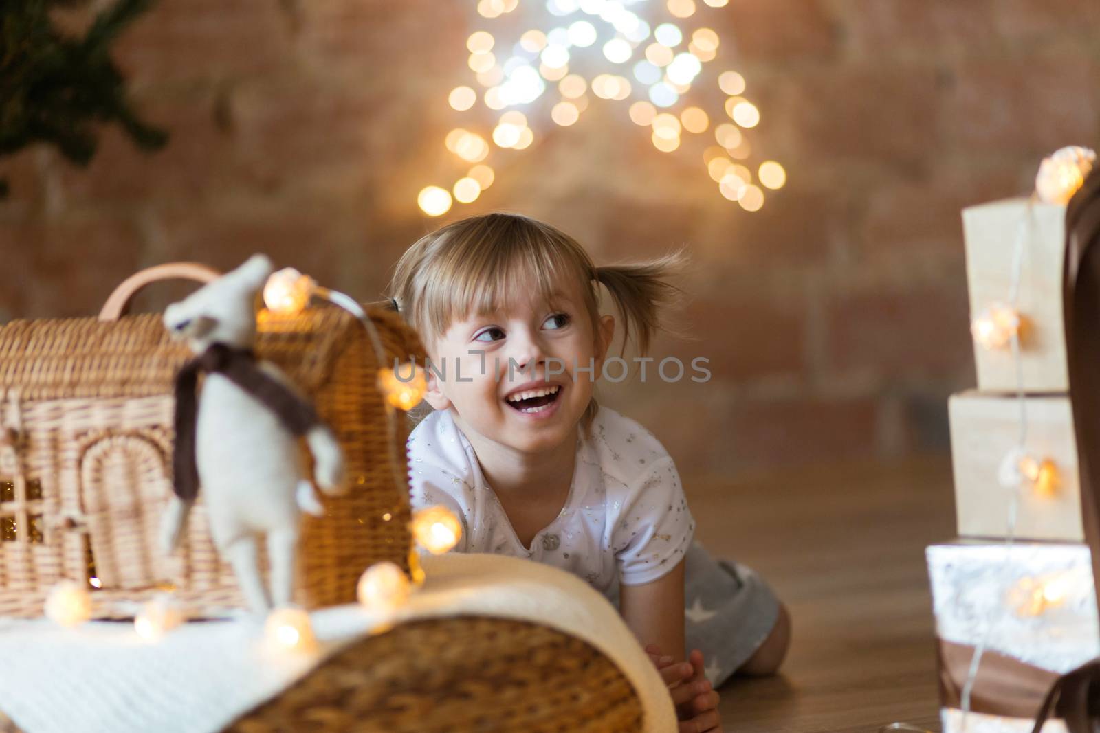 .Cute little girl sitting on the floor among the new year garlands by galinasharapova