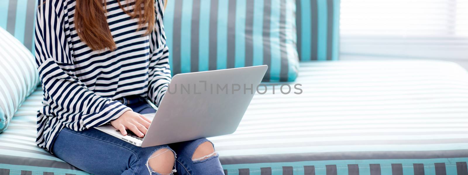 Banner website young asian woman using laptop for leisure on sof by nnudoo