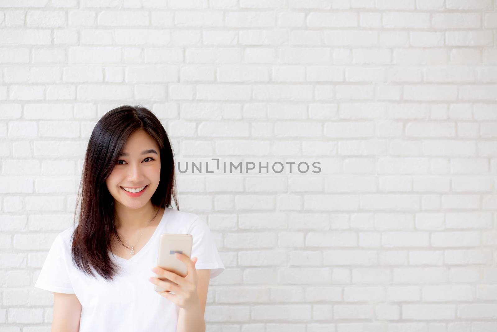 Beautiful of portrait young asian woman touch phone and smile st by nnudoo