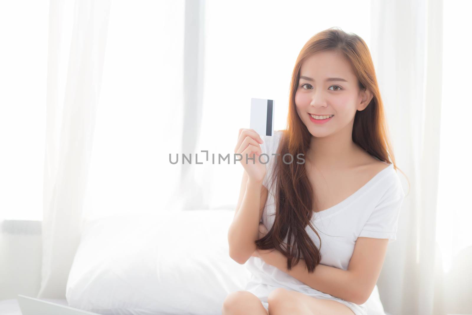 Beautiful portrait young asian woman shopping online with credit by nnudoo
