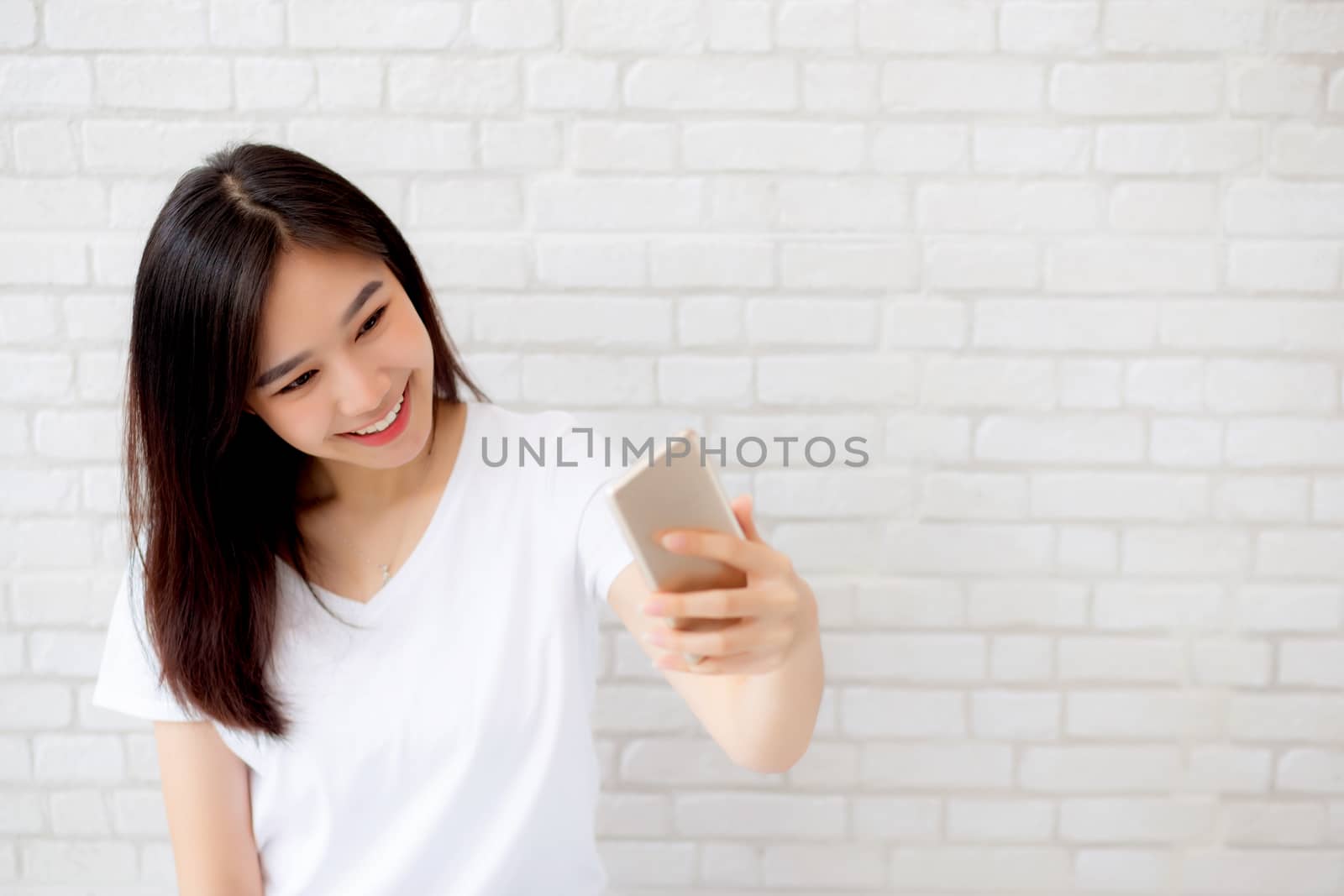 Beautiful portrait young asian woman taking a selfie with smart  by nnudoo