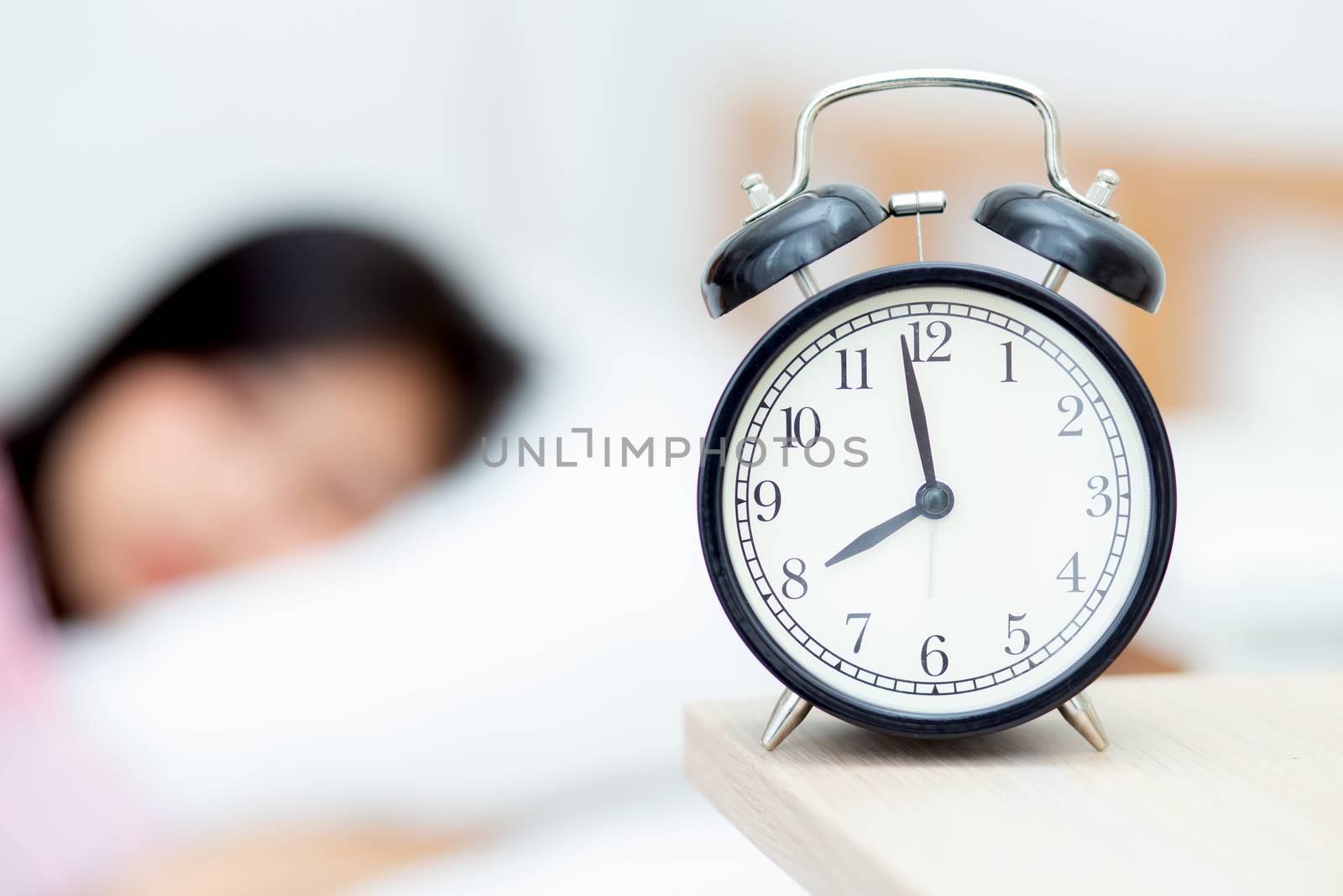 closeup alarm clock and beautiful asian young woman in morning, wake up for sleep with alarm clock, relax and lifestyle concept.