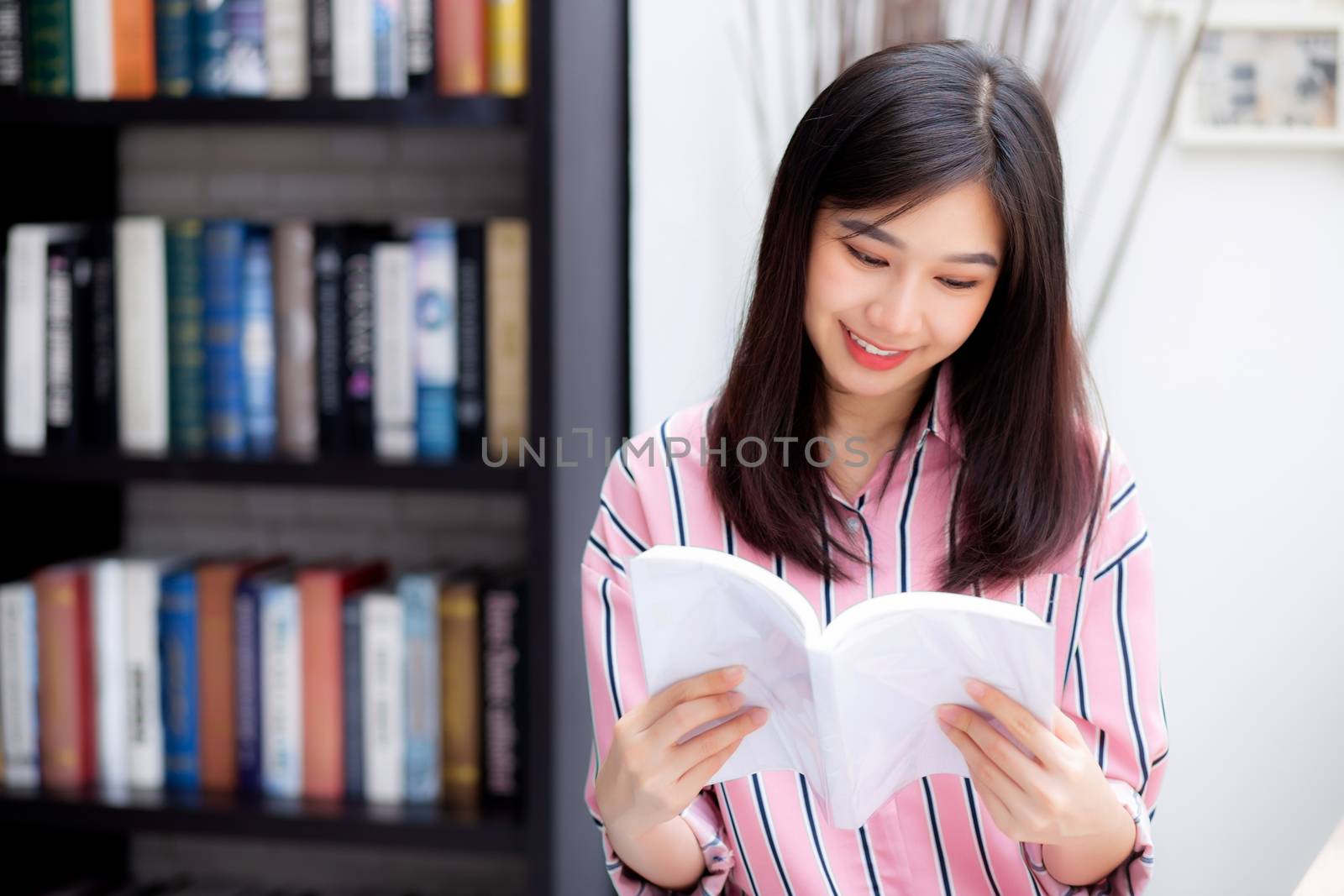 Beautiful of portrait young asian woman relax sitting reading book in living room at home, girl study literature, education and llifestyle concept.