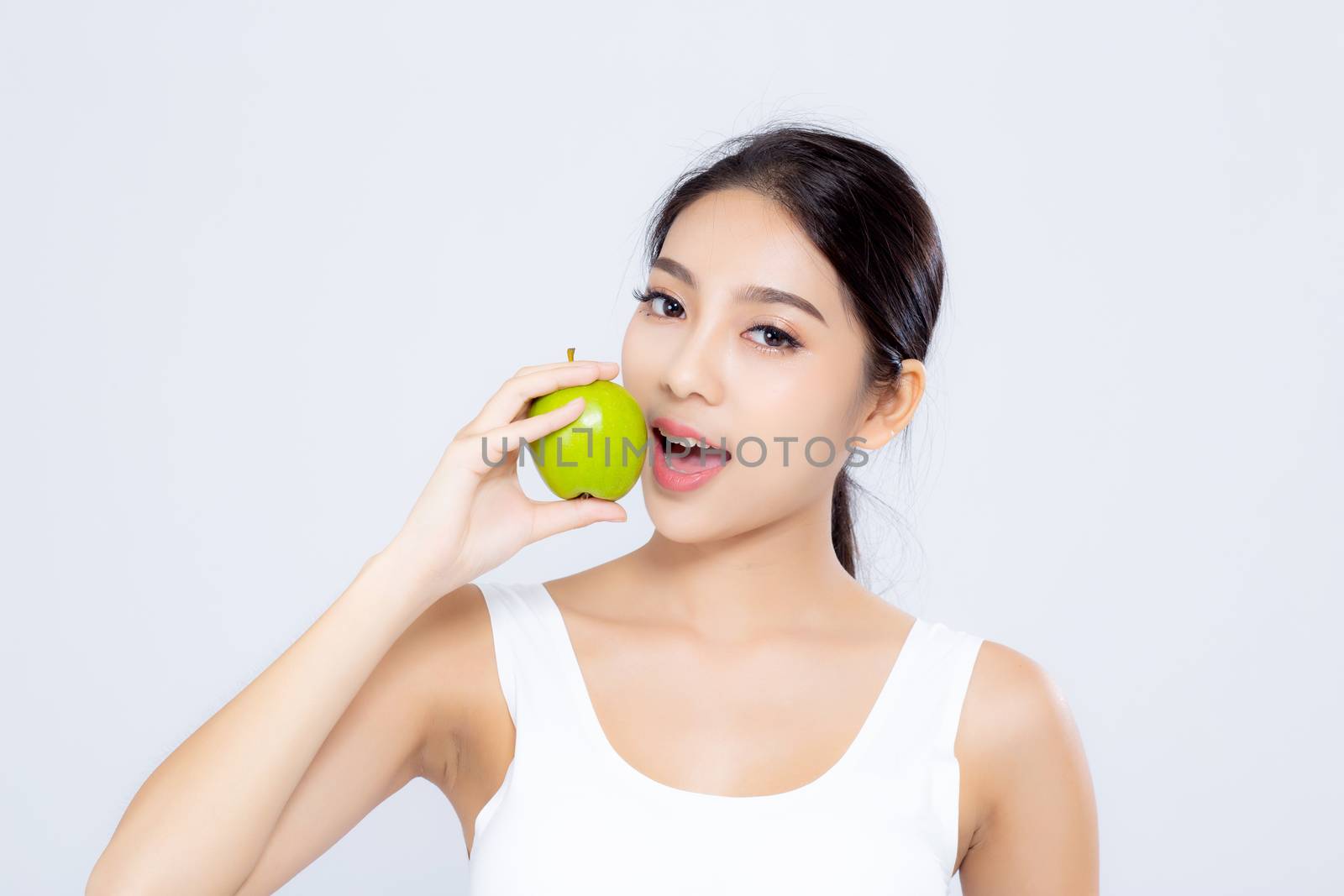 Portrait asian woman smiling holding and eating green apple fruit and beautiful body diet with fit isolated on white background, girl weight slim with cellulite or calories, health and wellness concept.