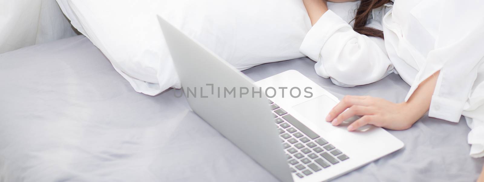 Banner website beautiful young asian woman with laptop lying down in bedroom, girl tired sleep with computer notebook, resting and healthcare concept.