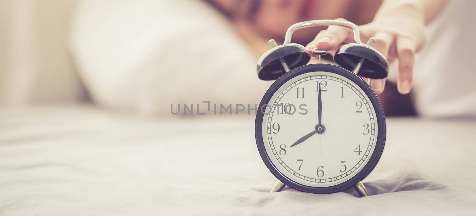 Banner website beautiful asian young woman turn off alarm clock  by nnudoo