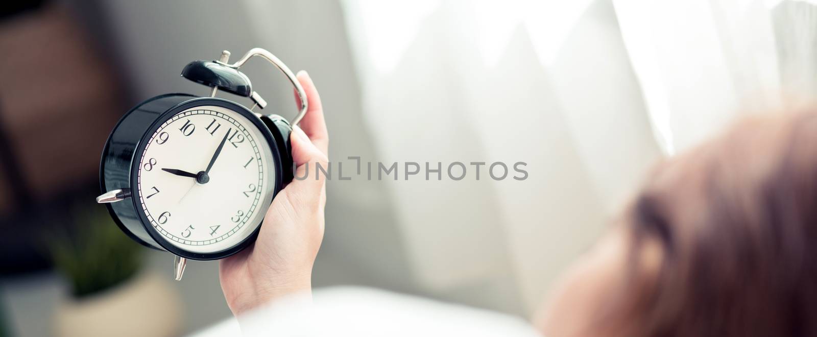 Banner website asian young woman turn off alarm clock in morning, wake up for sleep with alarm clock, relax and lifestyle concept.