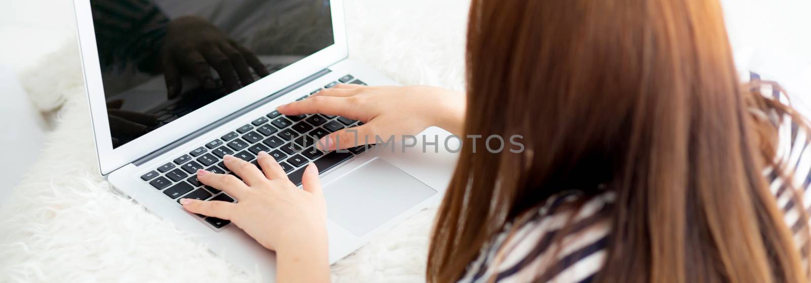 Banner website asian young woman lying on bed using laptop at bedroom for leisure and relax, freelance with girl working notebook, communication concept, top view.