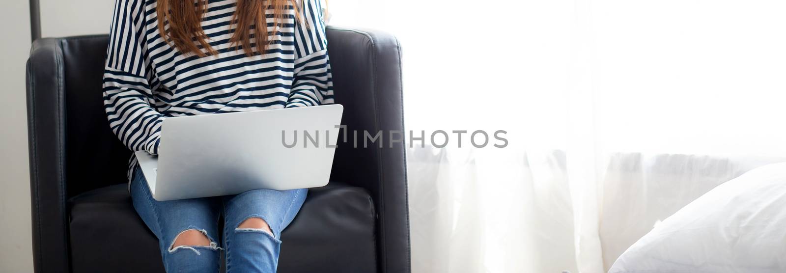 Baner website young asian woman using laptop computer  for leisure on chair at living room, girl working online with notebook freelance, communication business concept.