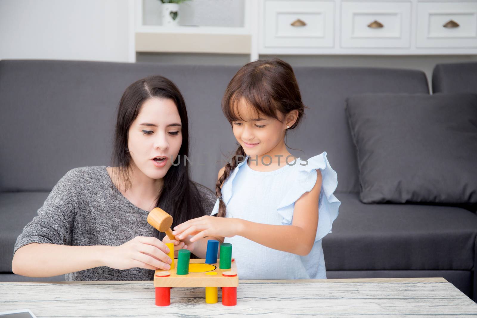 Mother and child play toy together on the living room at home, k by nnudoo