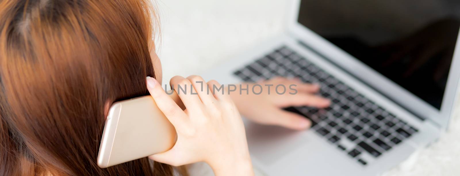 Banner website beautiful asian young woman lying on bed using laptop and talking mobile smart phone at bedroom for leisure and relax, freelance with girl working notebook, communication concept, top view.
