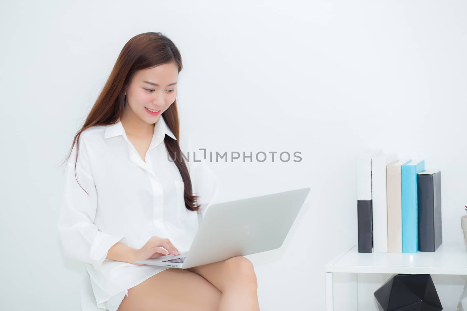 Beautiful young asian woman using laptop for leisure on sofa, girl working online with notebook freelance, communication business concept.