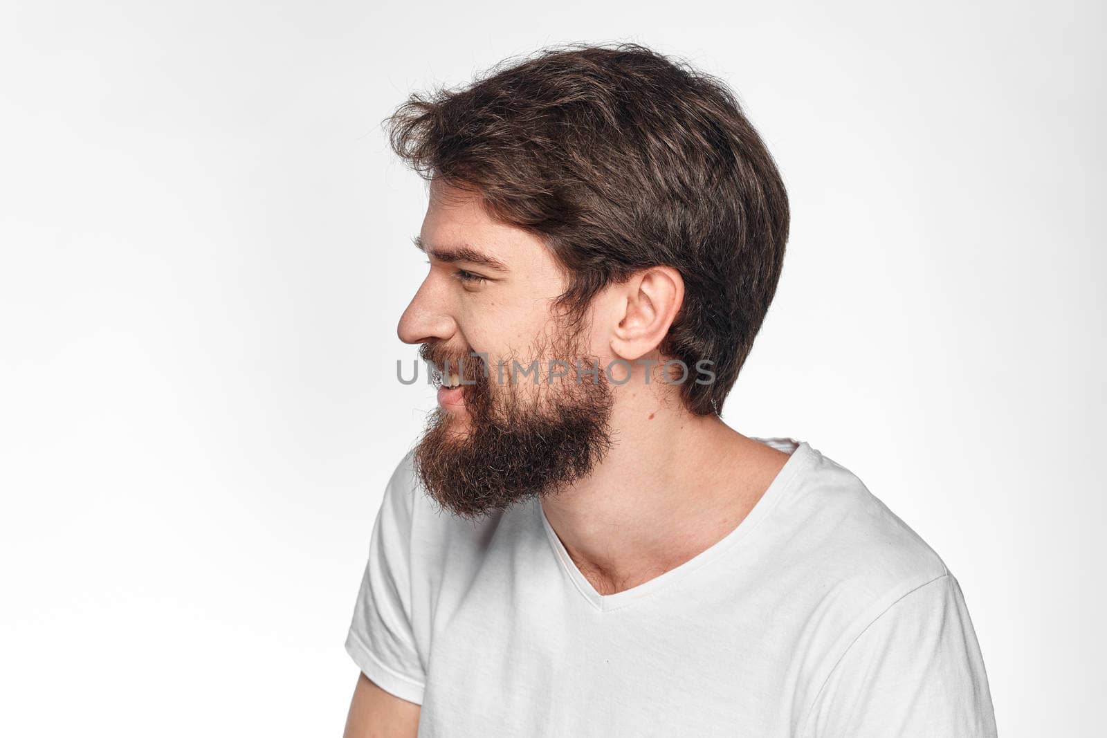 cheerful emotional bearded man gesturing with his hands close-up light background by SHOTPRIME