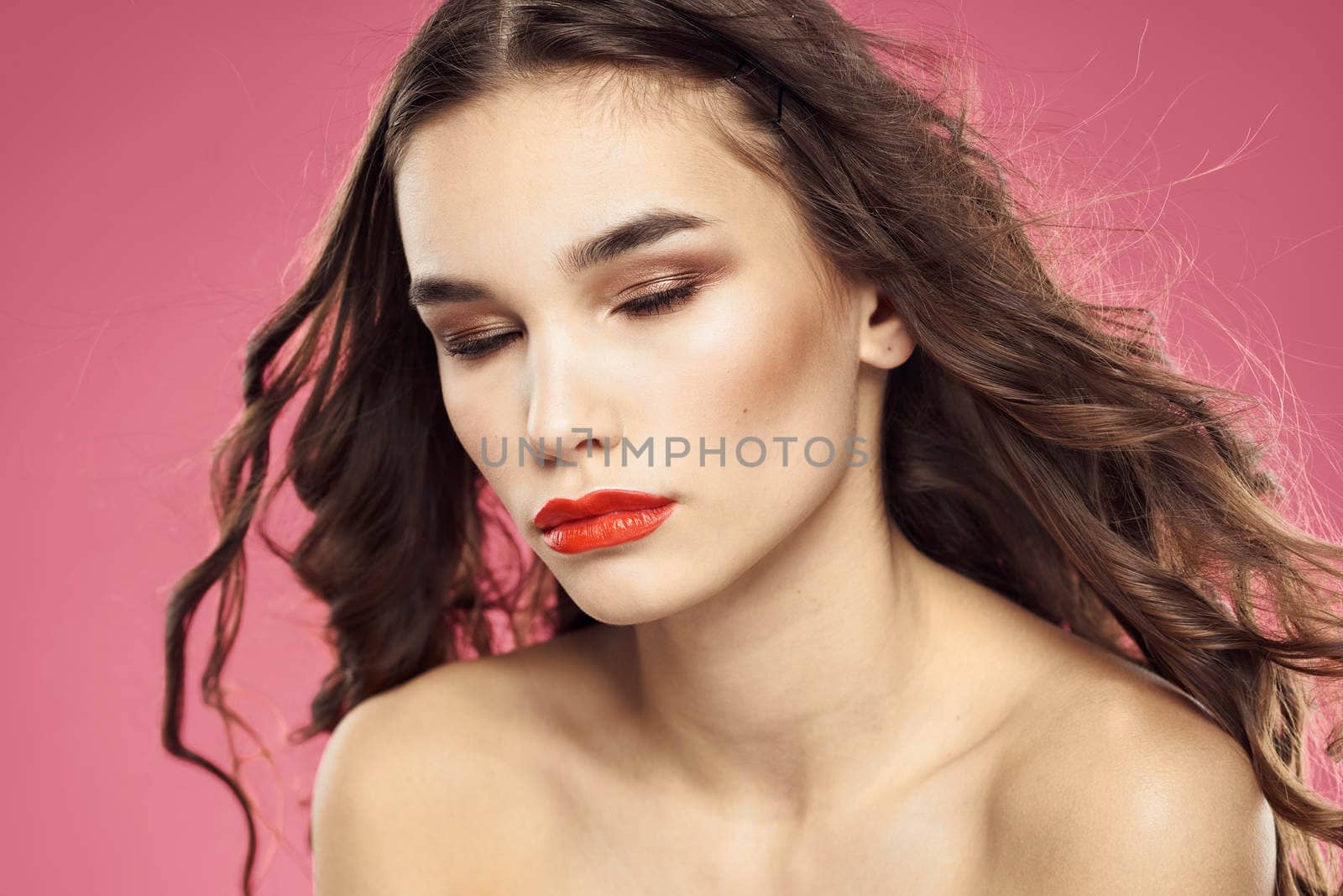 Attractive woman fashionable hairstyle bared shoulders and red lips pink background by SHOTPRIME