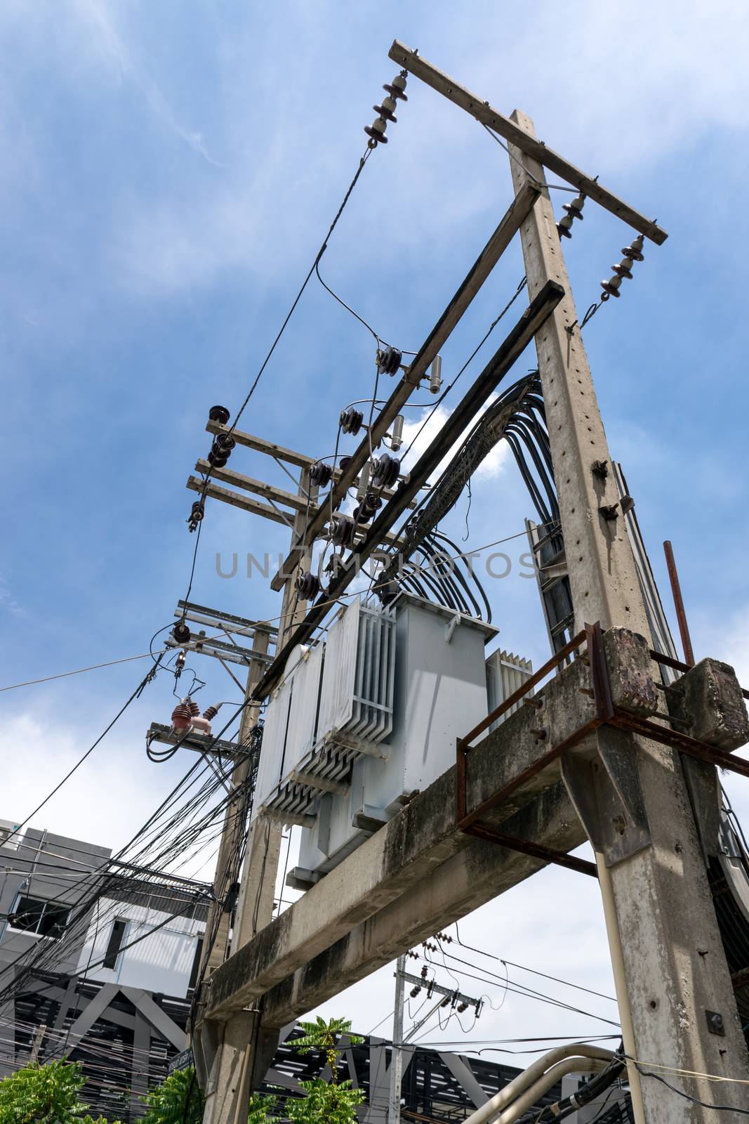 Transformer on electricity post on blue sky background.