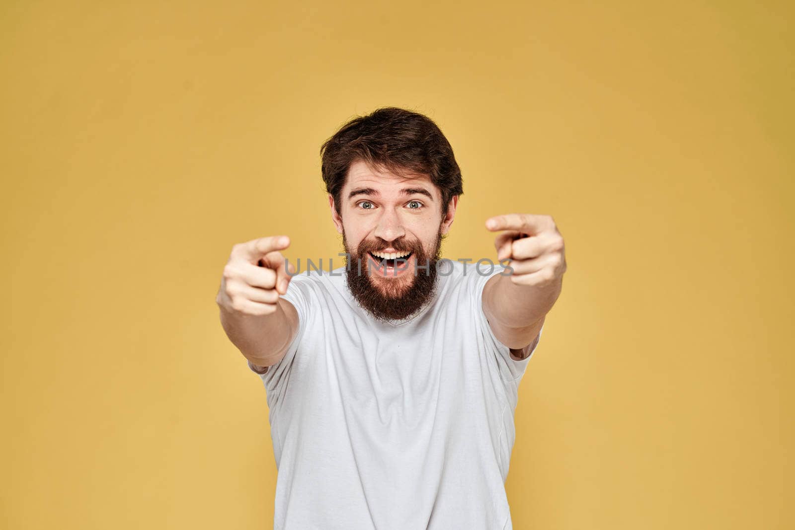 Bearded man on emotions white t-shirt fun lifestyle yellow background. High quality photo