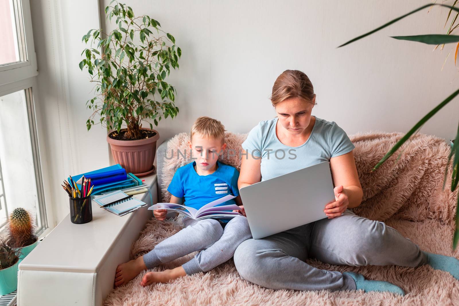 Mother with kid trying to work from home during quarantine. Stay at home, work from home concept during coronavirus pandemic