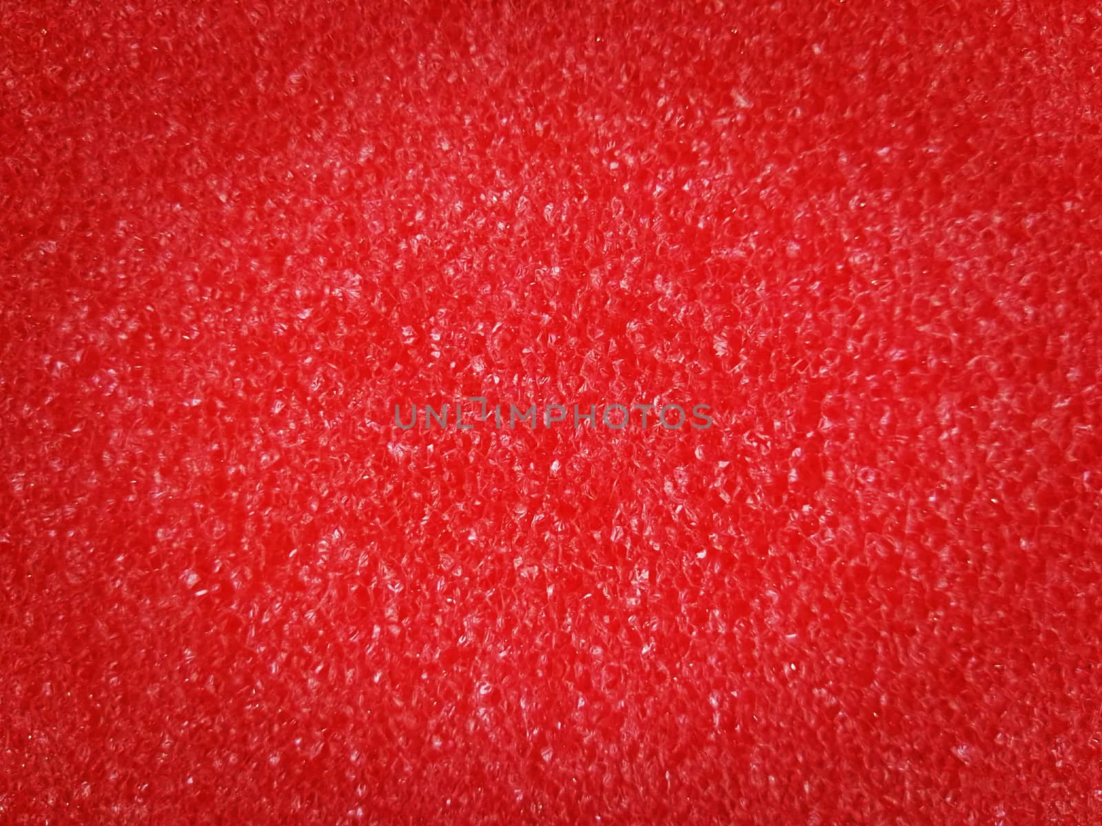 Red foam sponge texture background by wattanaphob