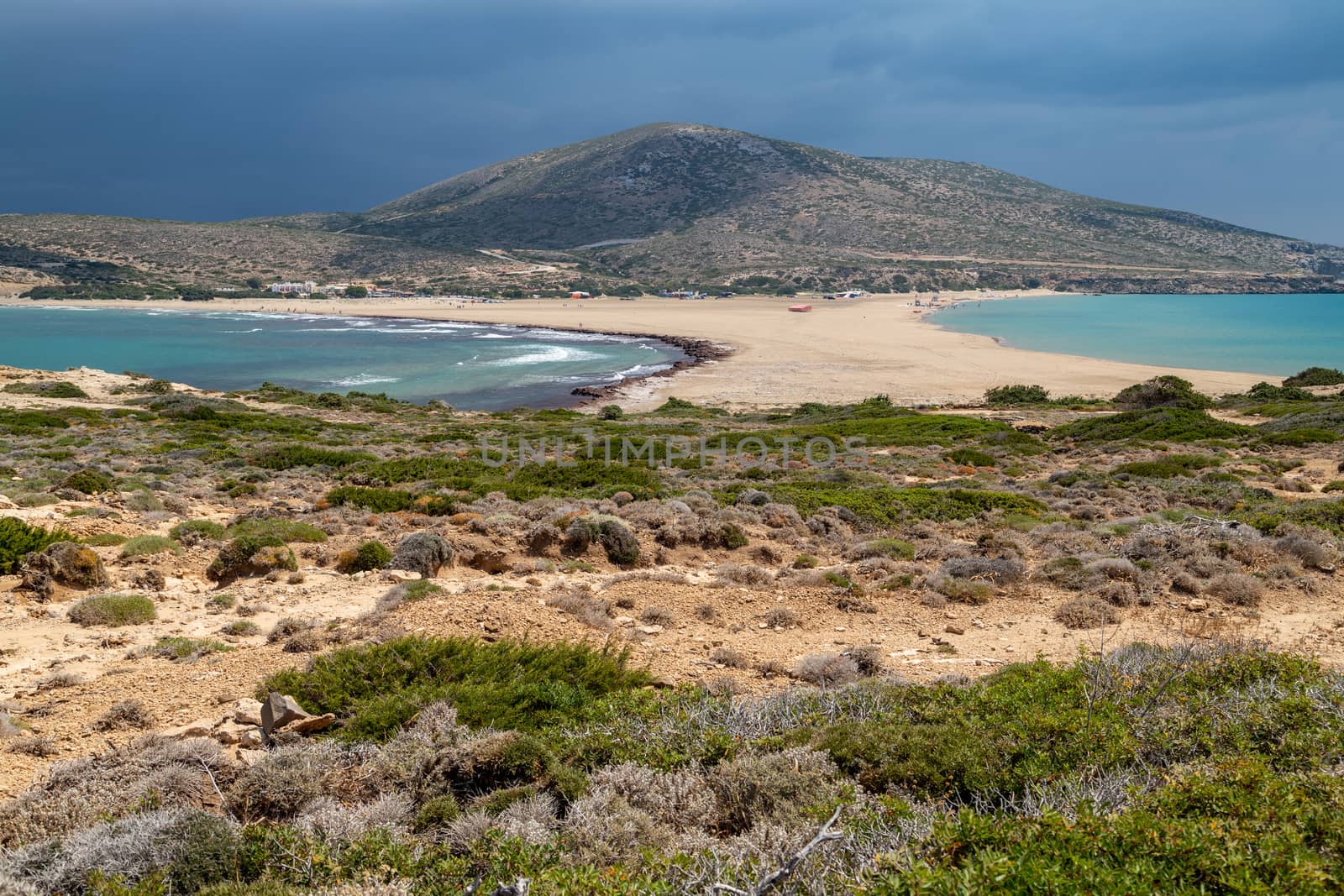 Scenic view from peninsula Prasonisi on Rhodes island, Greece with the aegean see on the right and the mediterranean see on the left side with dark sky before a thunderstorm