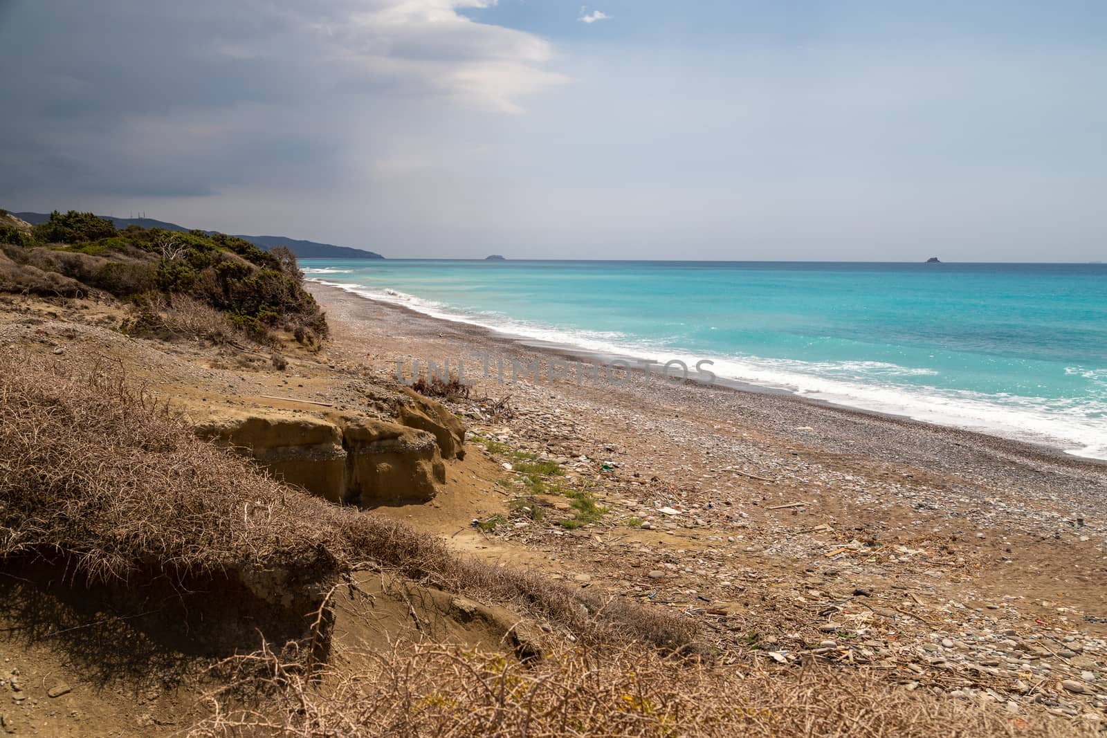 Gravel / pebble beach at the westcoast of Rhodes island near Kattavia with ocean waves and turquoise water