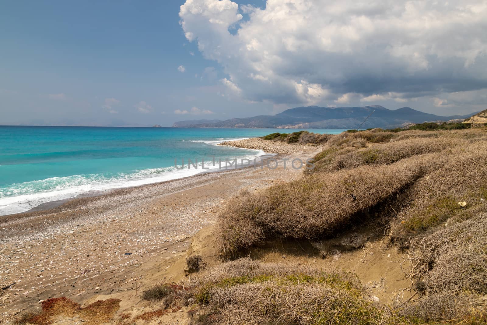 Gravel / pebble beach at the westcoast of Rhodes island near Kattavia with ocean waves and turquoise water