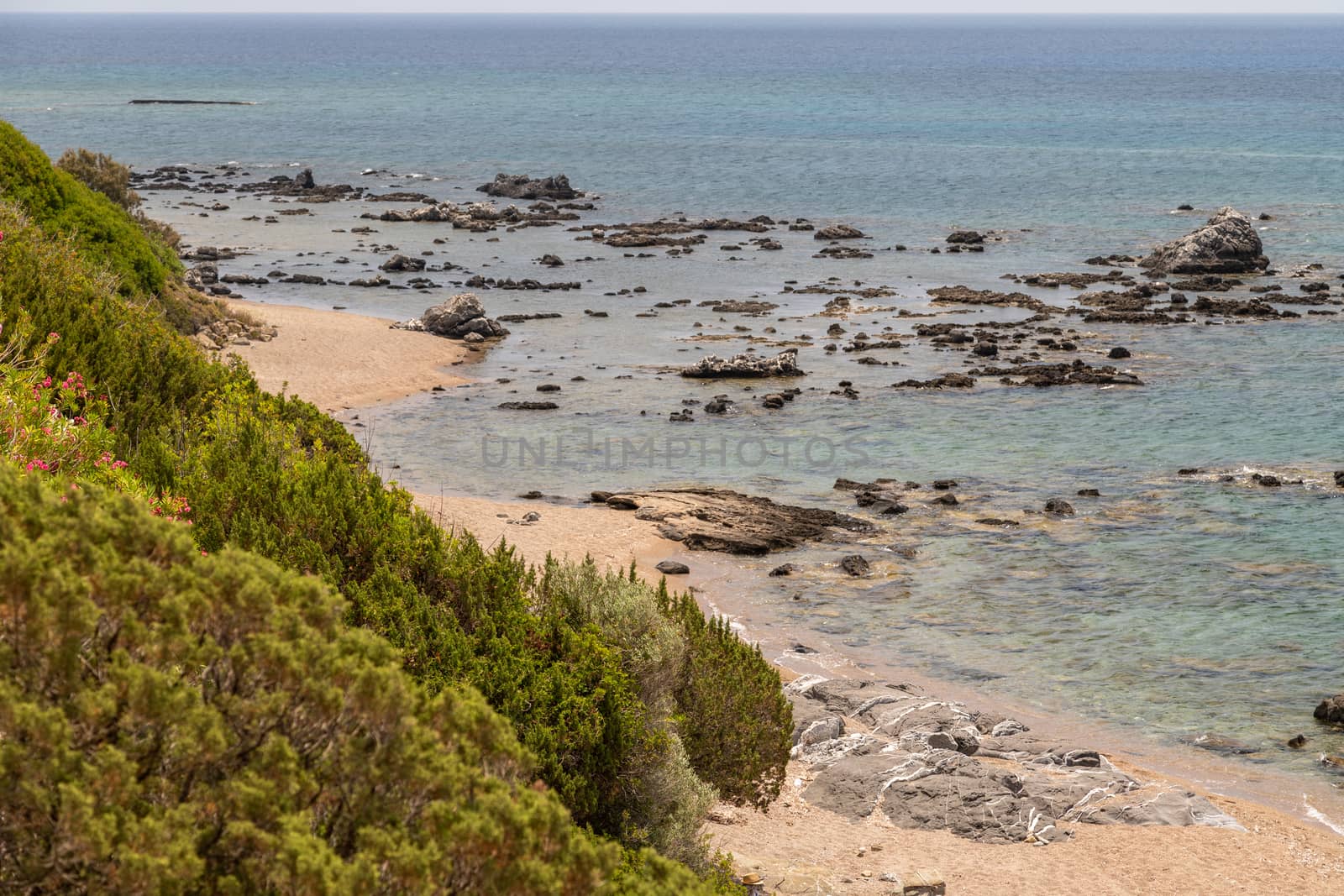 Coastline of Kiotari on Rhodes island, Greece with gravel beach and rocks in the water