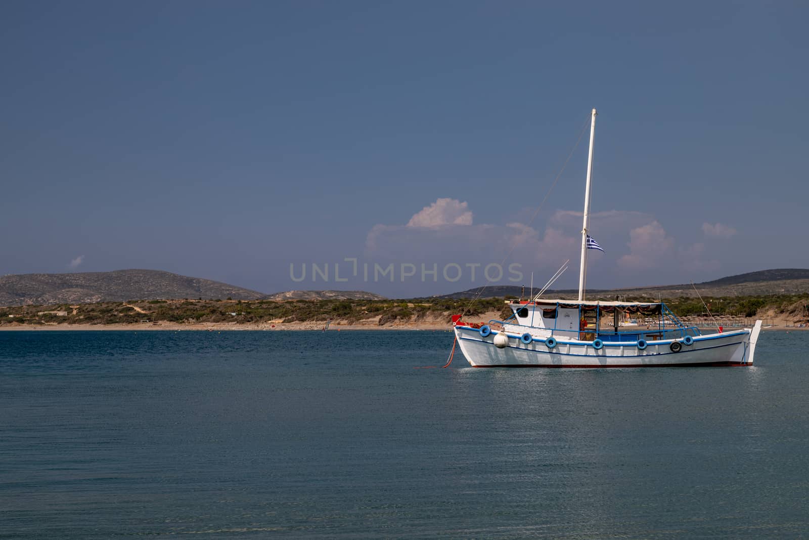 Fishing boat in the bay of Plimmiri at Rhodes island, Greece and mountain range in the background on a sunny day in summer
