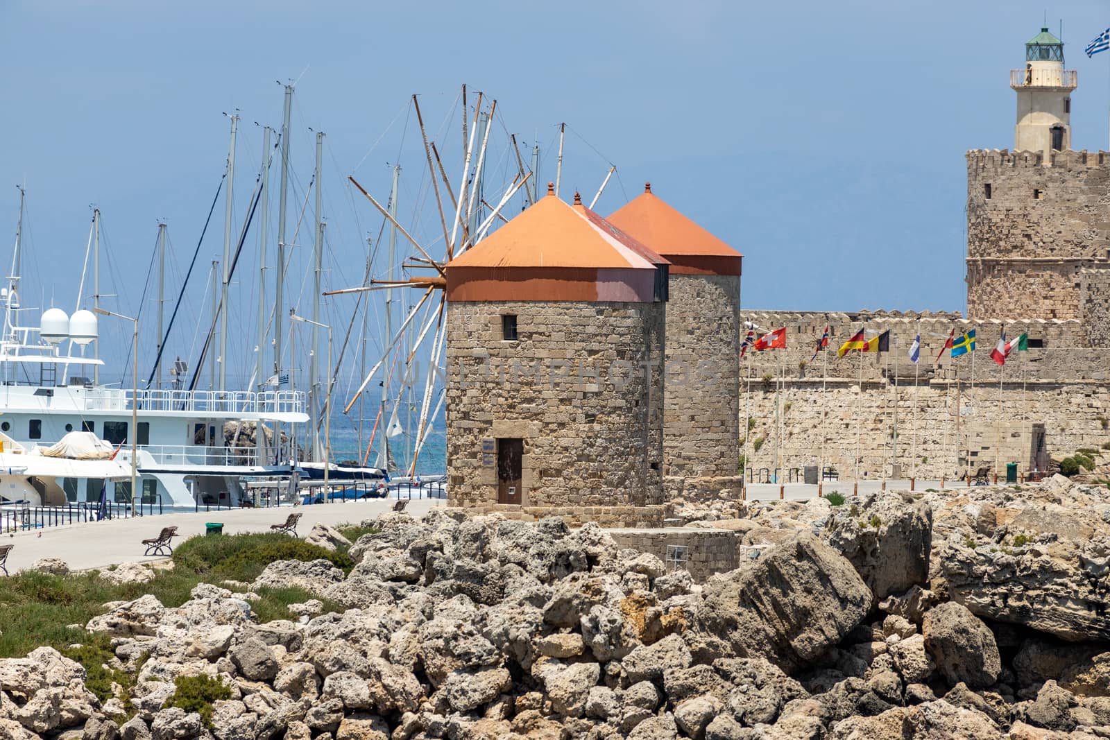 Mandraki  harbour in Rhodes city with old windmills and Kastell Agios Nikolaos with lighthouse   by reinerc