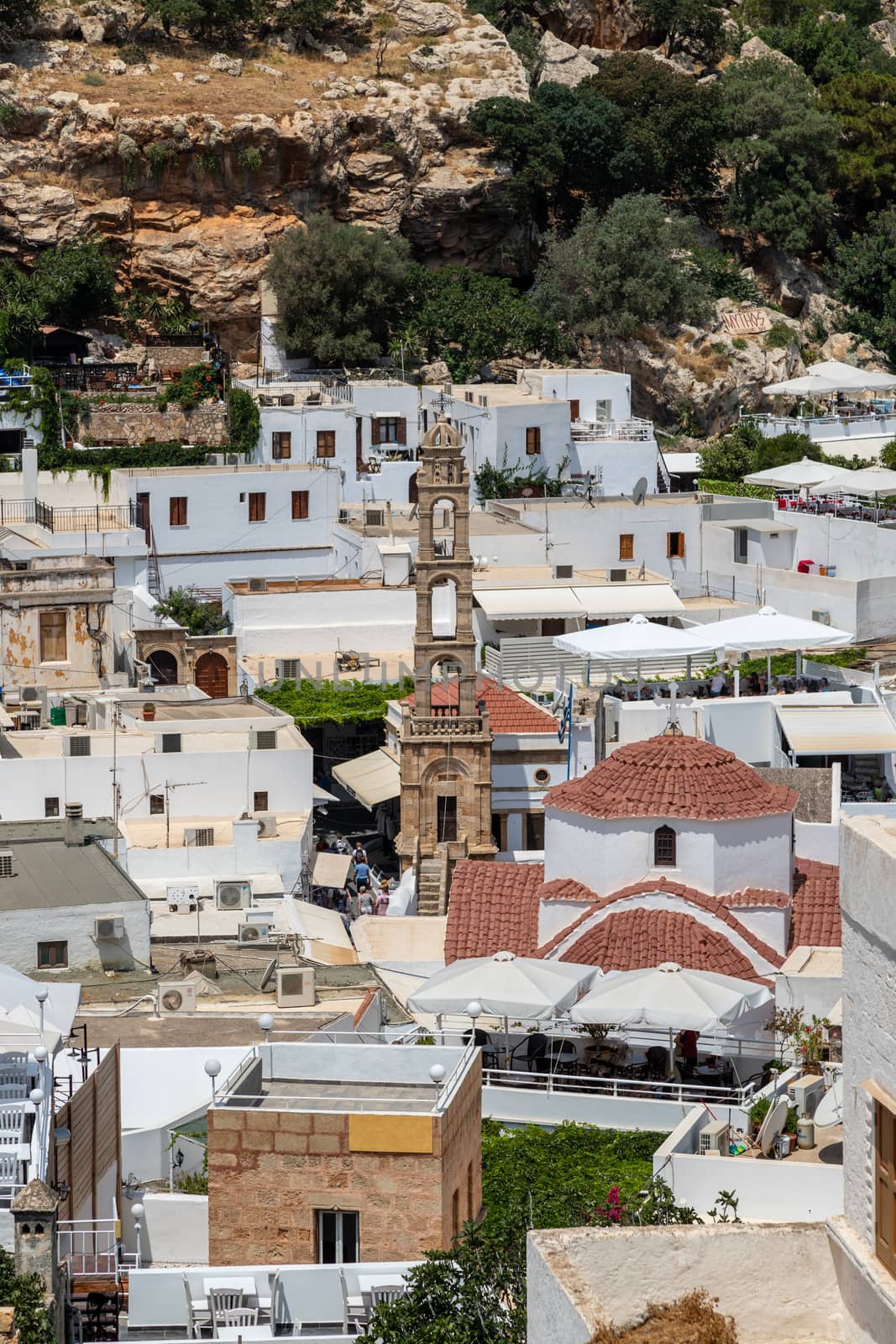 View at the city of Lindos on Greek island Rhodes with white houses and mountain in the background on a sunny day in spring
