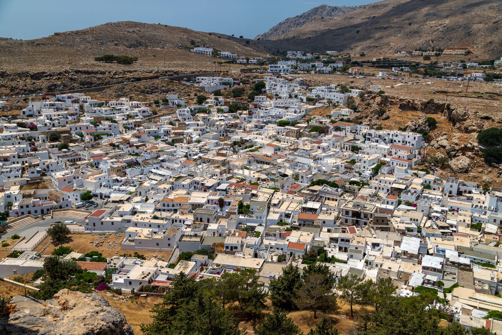 View at the city of Lindos on Greek island Rhodes with white houses and mountain in the background on a sunny day in spring