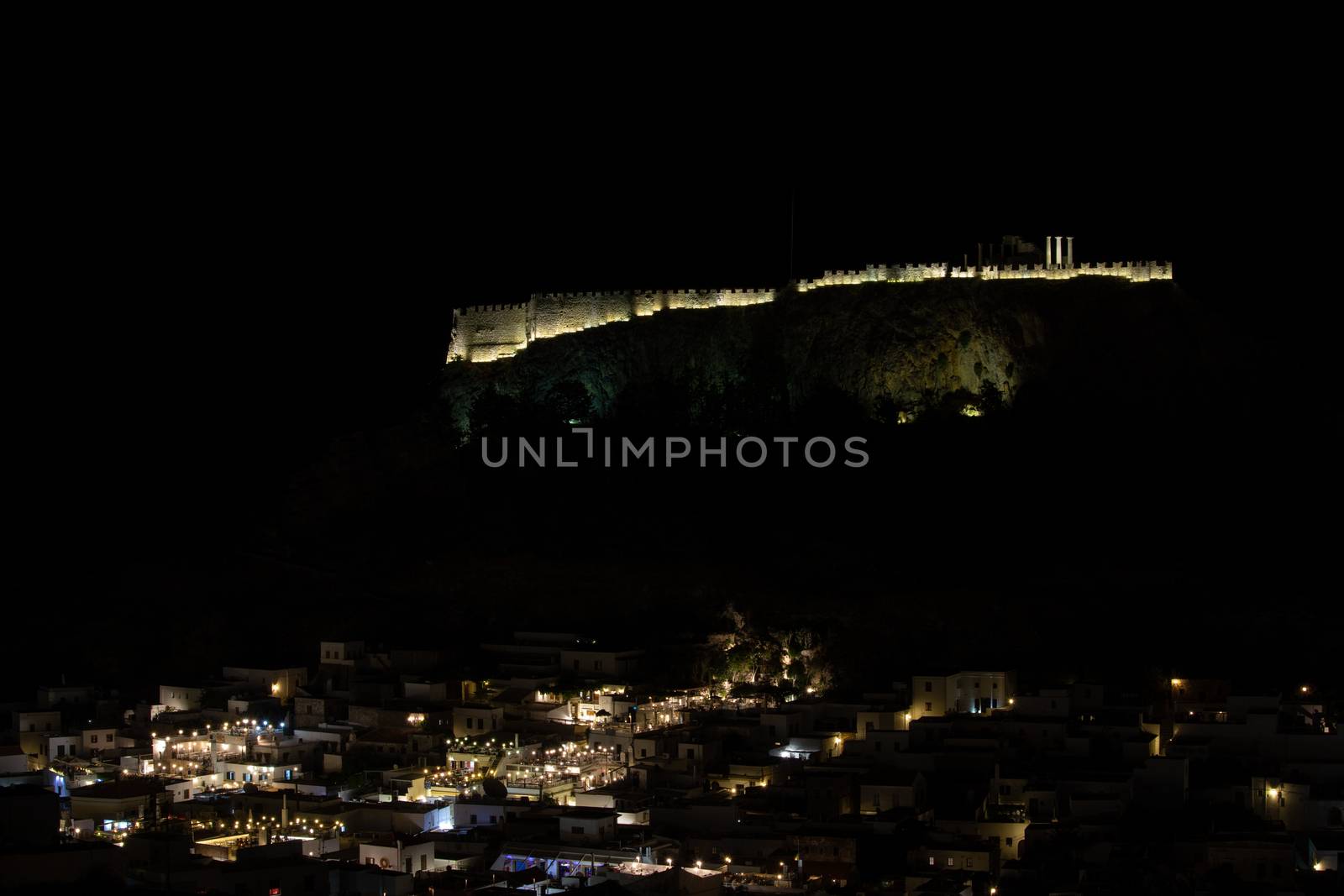 View at the illuminated city of Lindos and the acropolis by nigh by reinerc